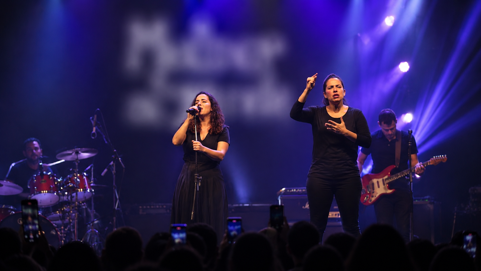 Intérprete de Libras fazendo a janela de Libras em um show de música